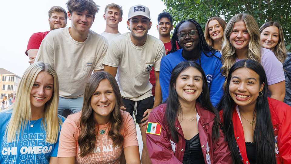 Thirteen sorority and fraternity members pose in a group photo. September 2023.