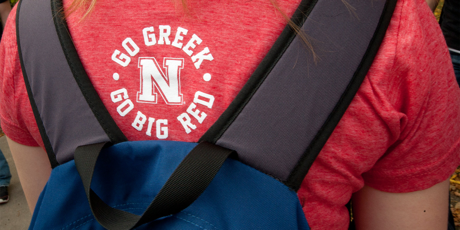 Back of Go Greek t-shirt worn by student